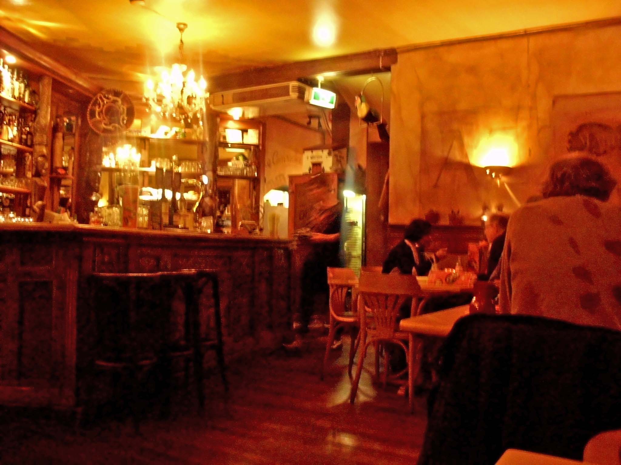 a dimly lit restaurant with several people sitting in chairs