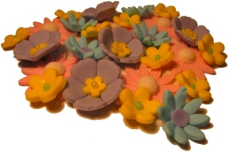 the small yellow and purple flower cookies are on the table
