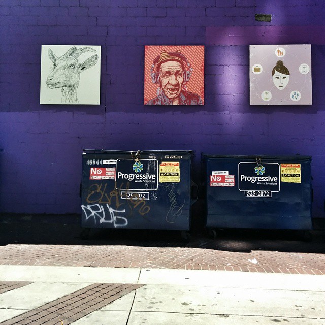 an artistic artwork on a purple wall with black trash cans