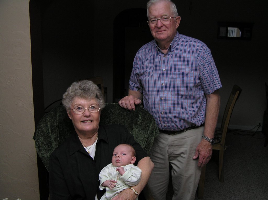 man holding a baby and woman standing next to him
