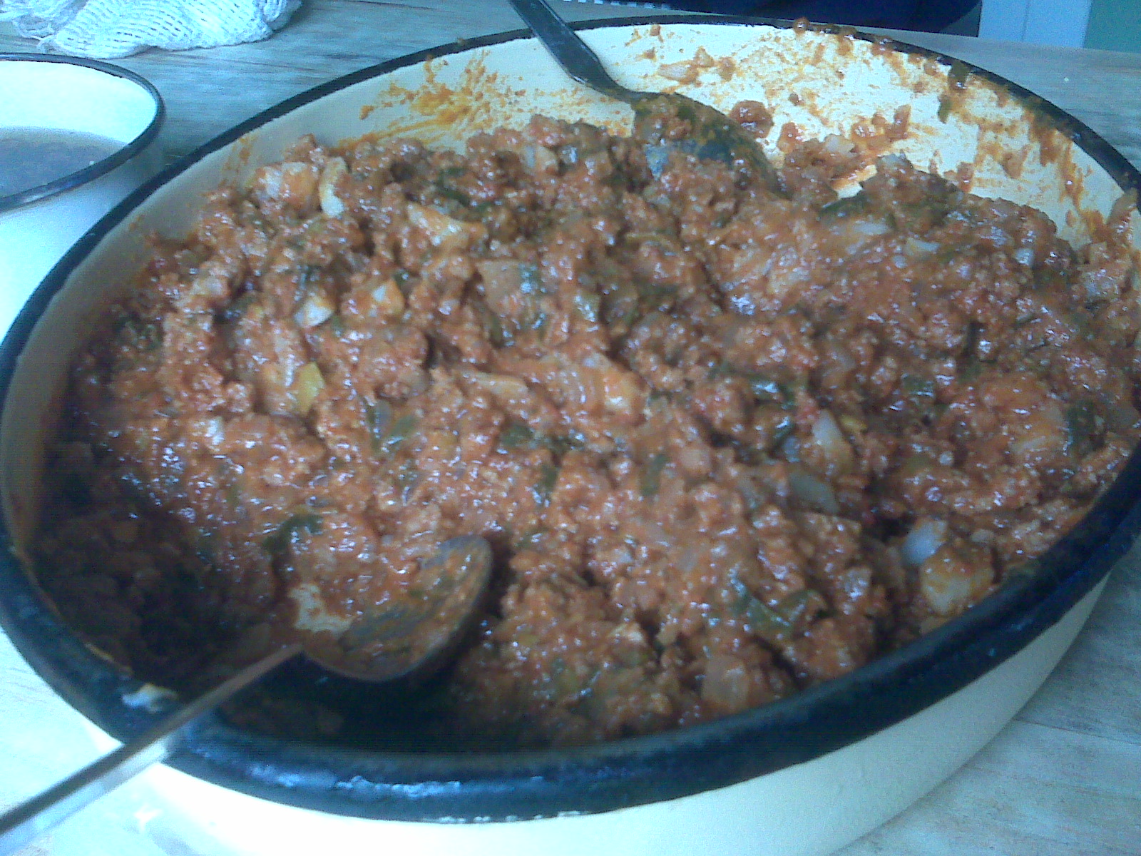 a bowl of ground beef and greens covered with herbs