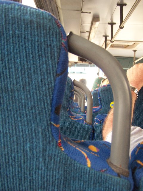 man laying in a seat on a public bus