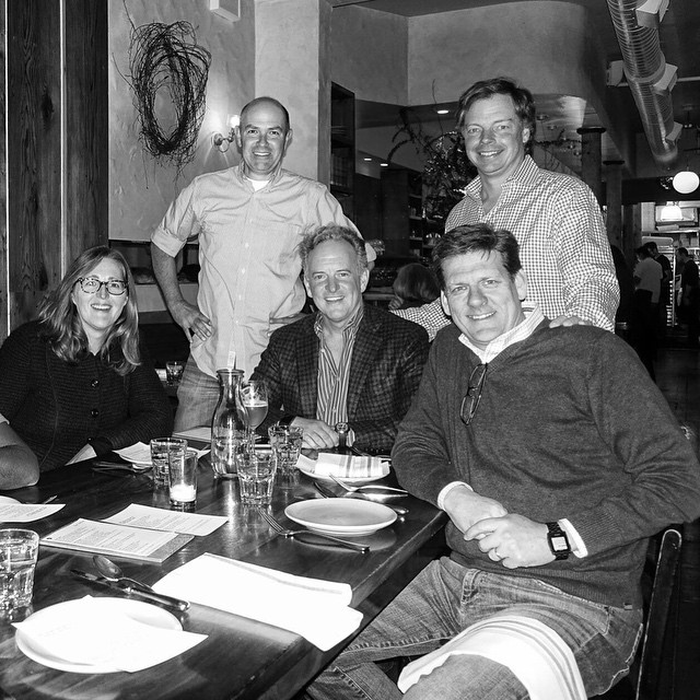 group po of people sitting at dinner table in black and white