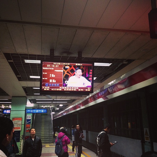 people are waiting on a train platform in a subway station