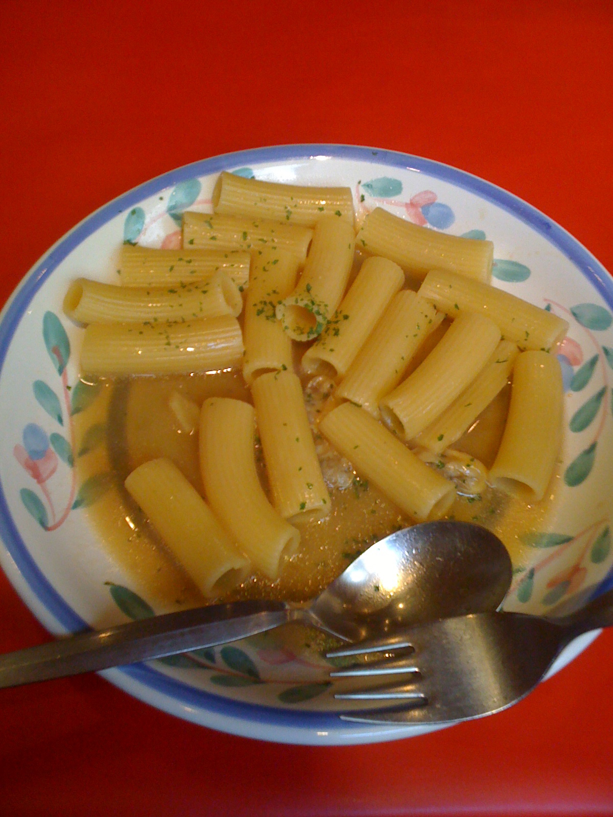 a dish full of macaroni and cheese on a table with spoons