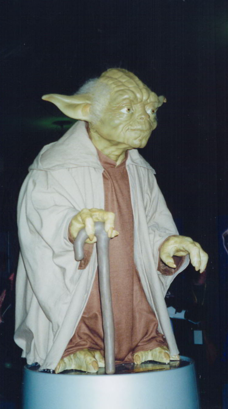 a po of yoda with a cane on a pedestal