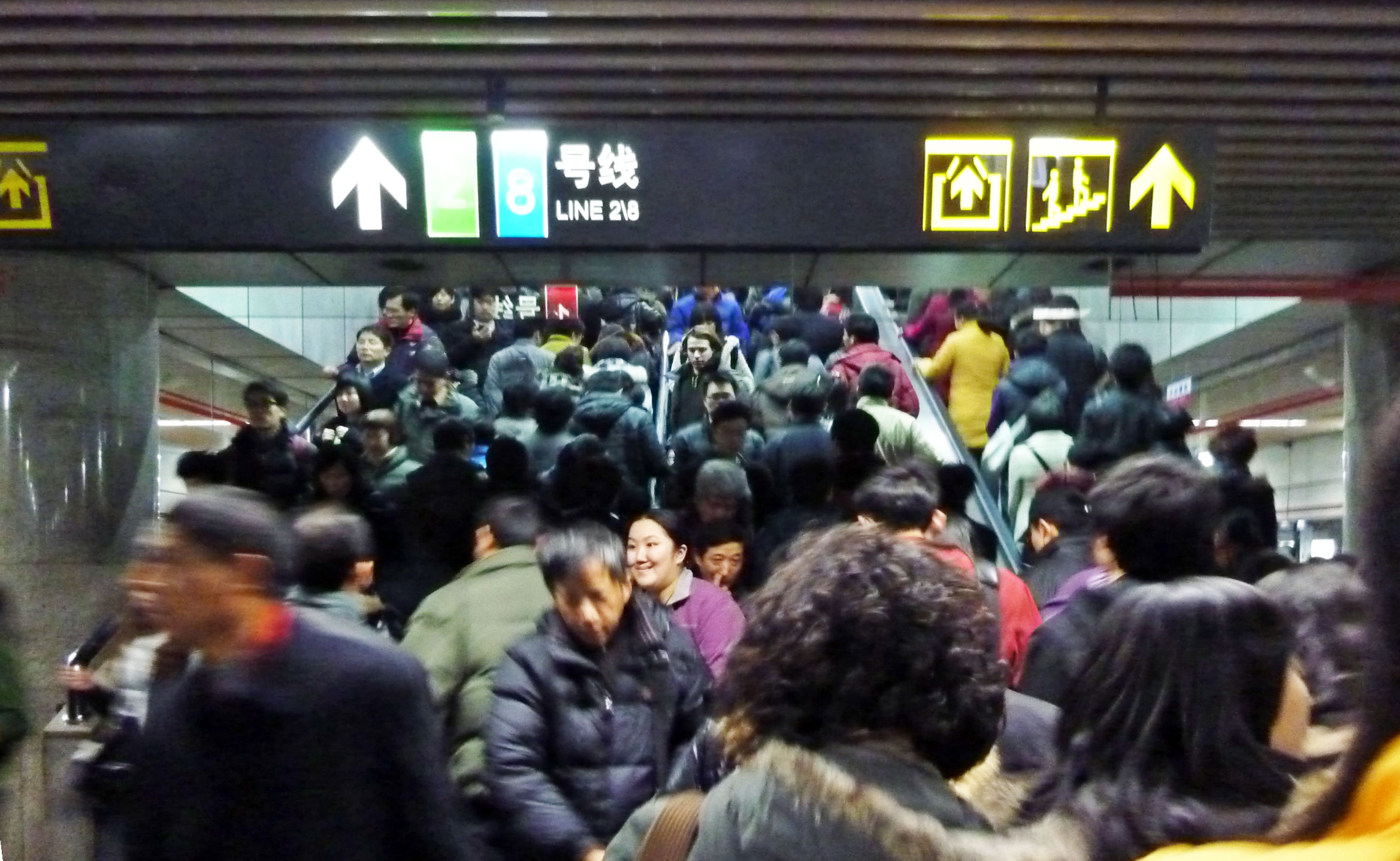 large crowd of people standing under a ceiling of information