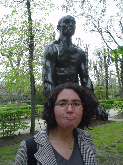 a woman standing in front of a statue of a man