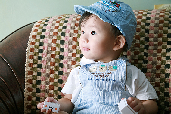 a small child in overalls and a blue hat