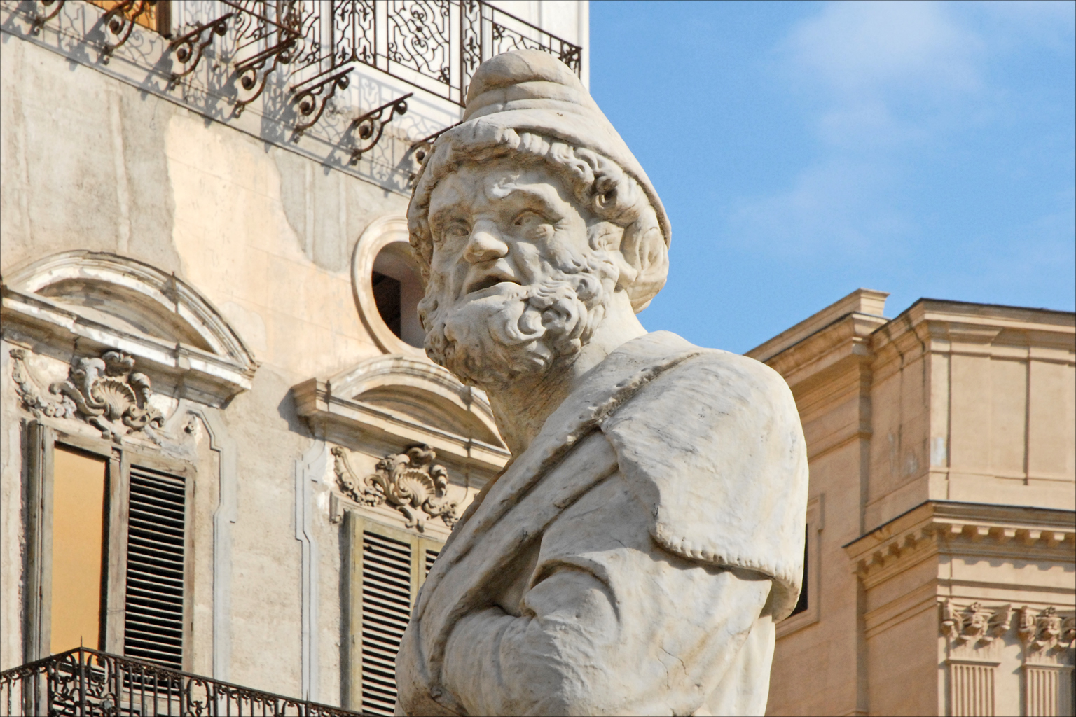 an old statue is standing outside a building