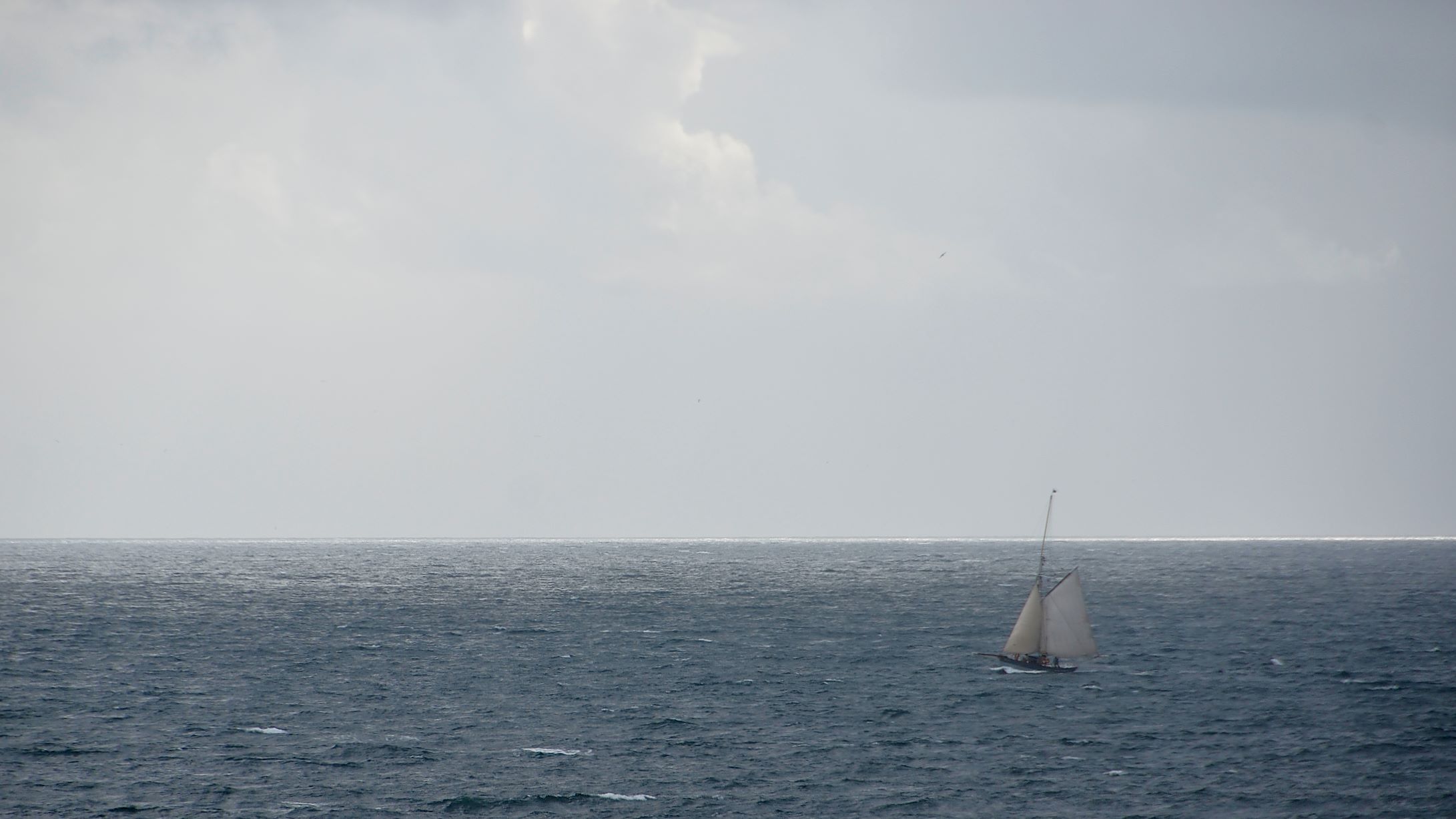 the sail boat in the open ocean is white