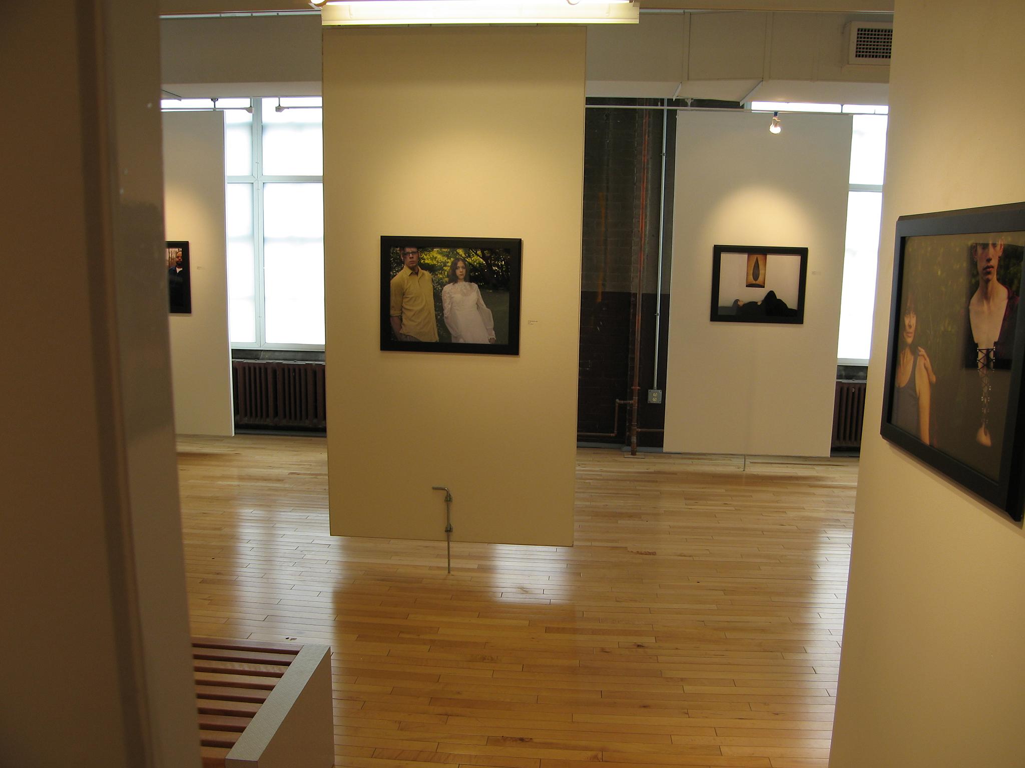 a white walled room with various pictures hanging on the wall