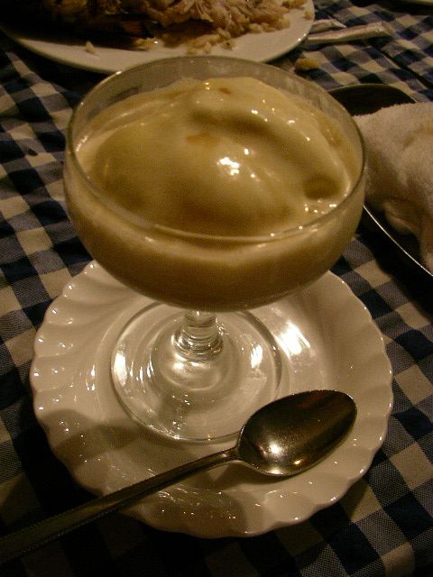 a desert served with ice cream in a small bowl on a white plate