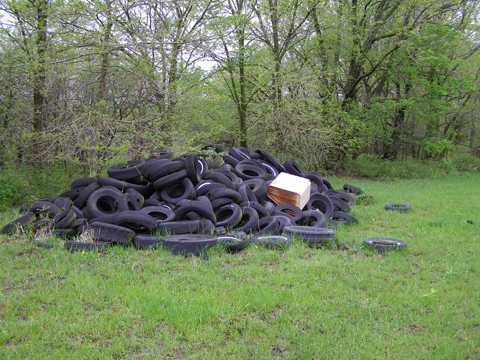 a pile of old bicycle tires laying on the ground in a field