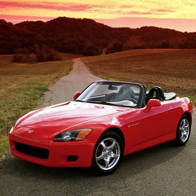 a beautiful red sports car driving down a road