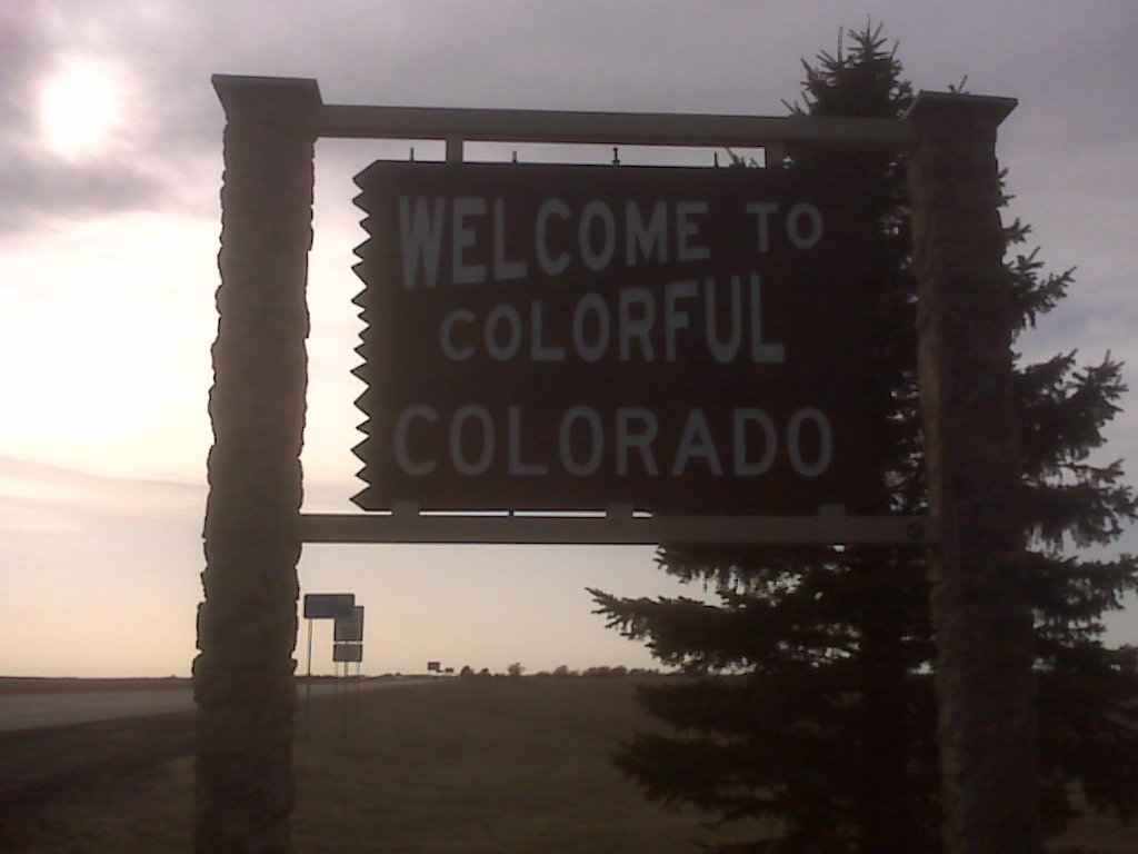 a welcome sign in the sunset on a grassy area