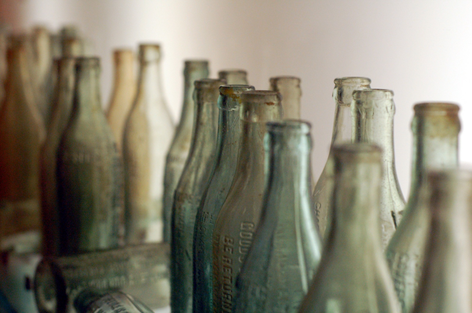 a bunch of glass bottles are all lined up