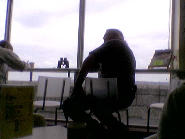 a man sitting at a table looking out the window