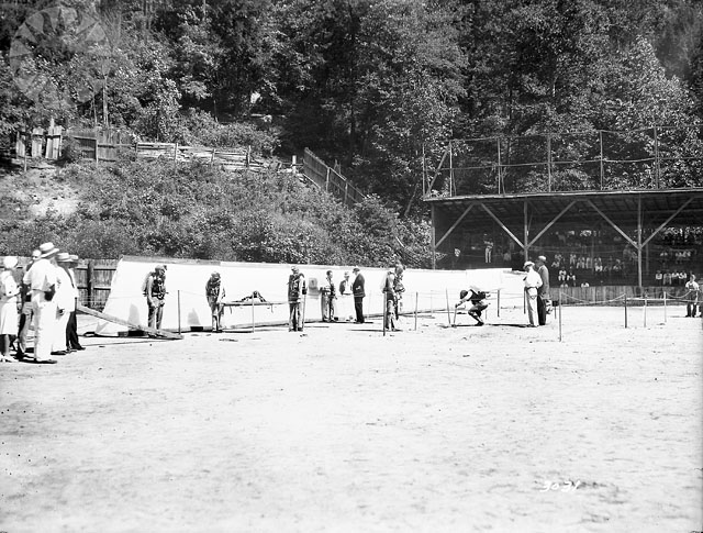 men stand by some tents in an open field