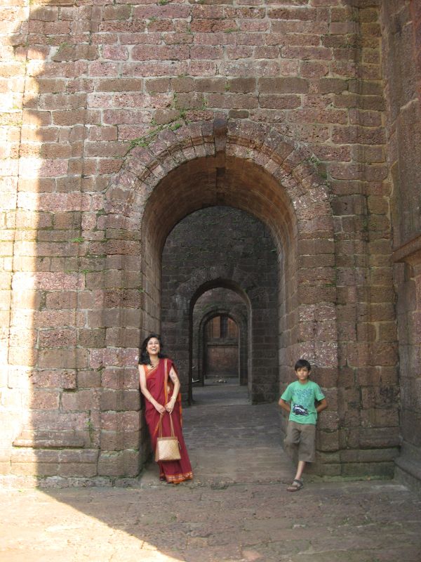 two people standing in an archway between two buildings