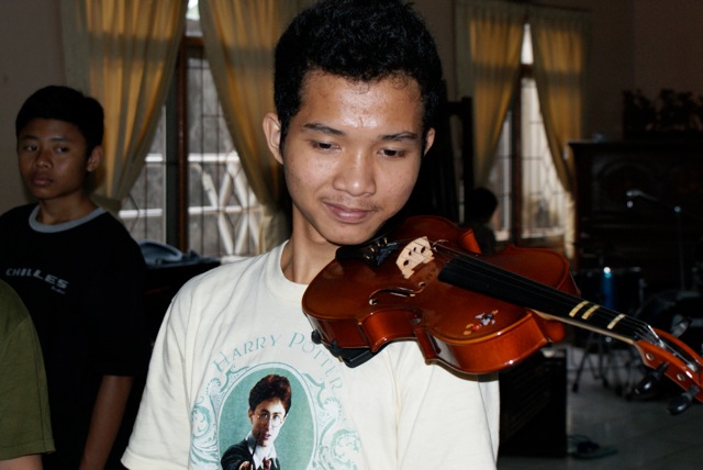 man with violin in residence near several guys