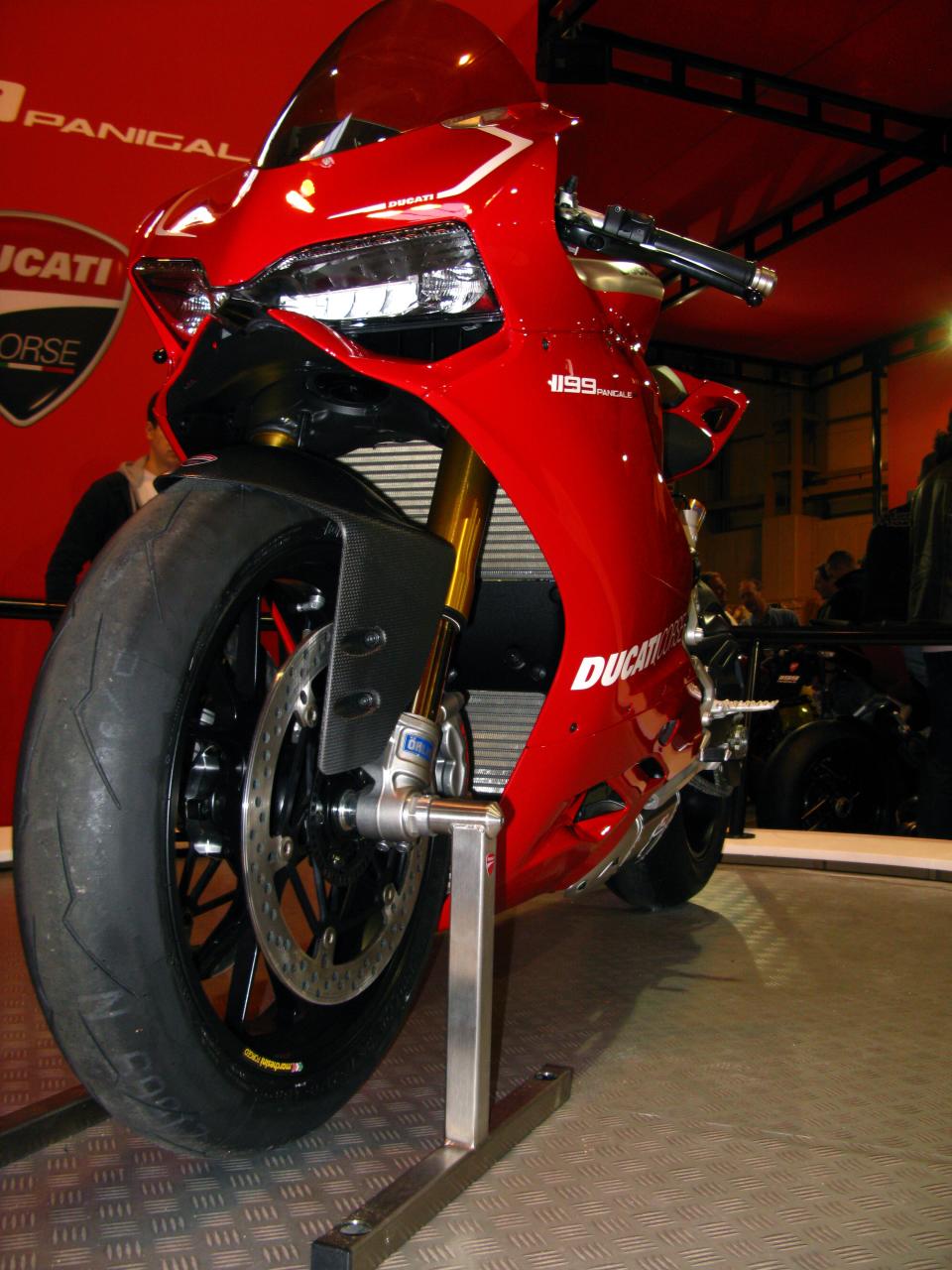 the front wheel of a red motorcycle at a motorcycle show