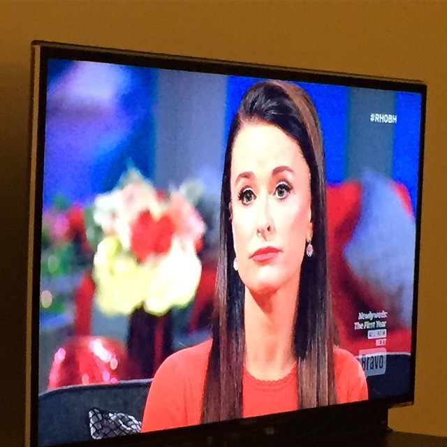 a tv showing the tv screen for news with a woman in red