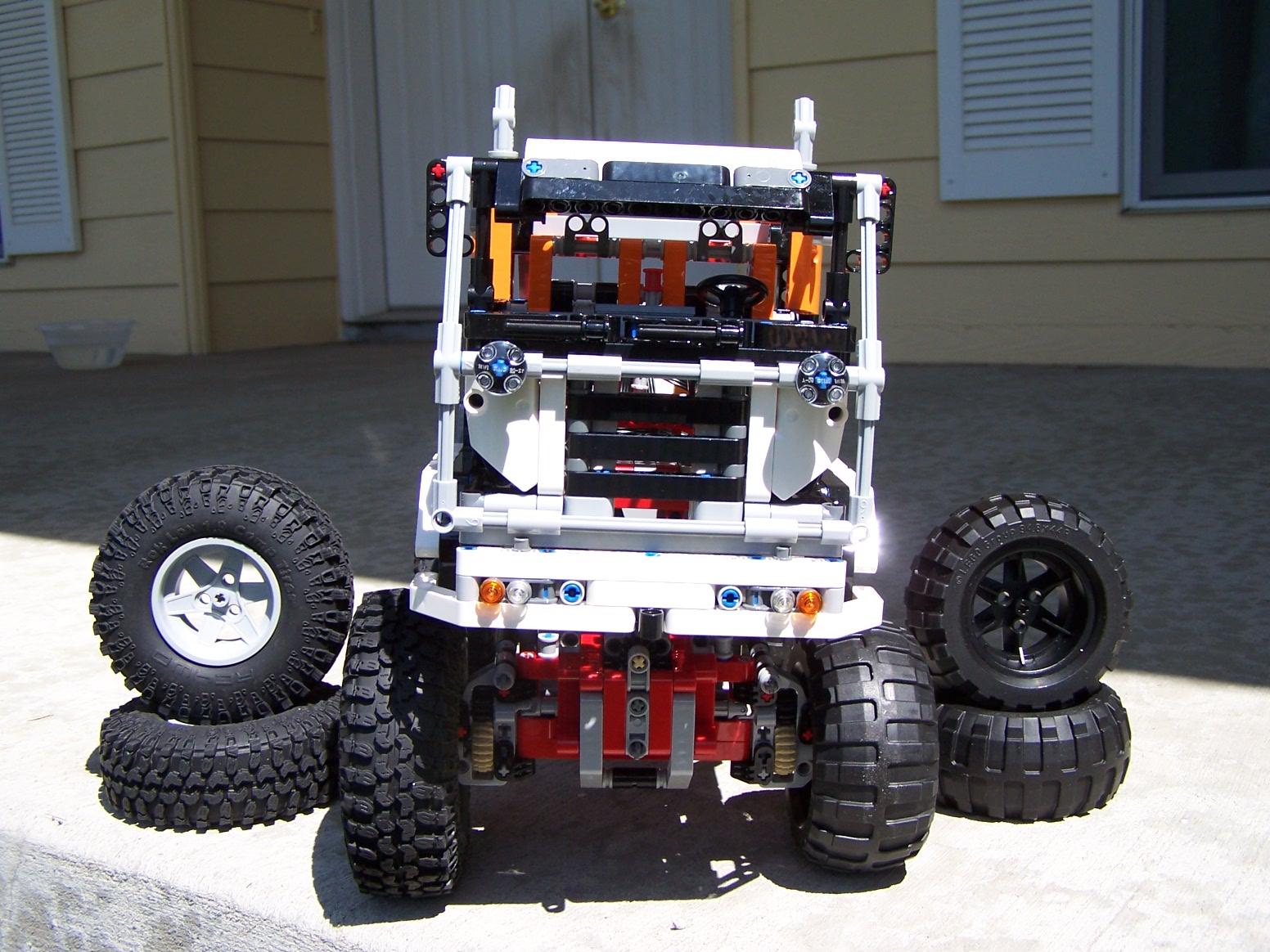 a large toy truck with wheels in front of a building