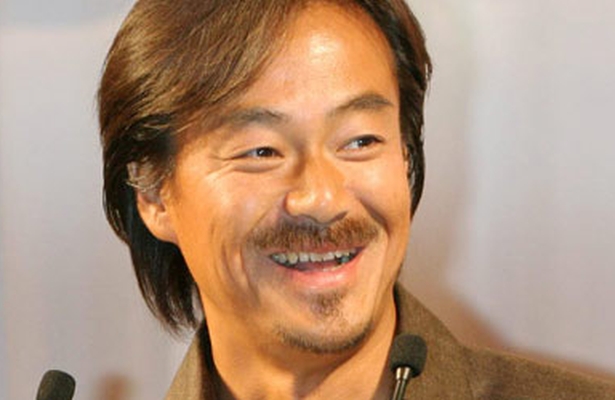 an asian man with a moustache and a smile
