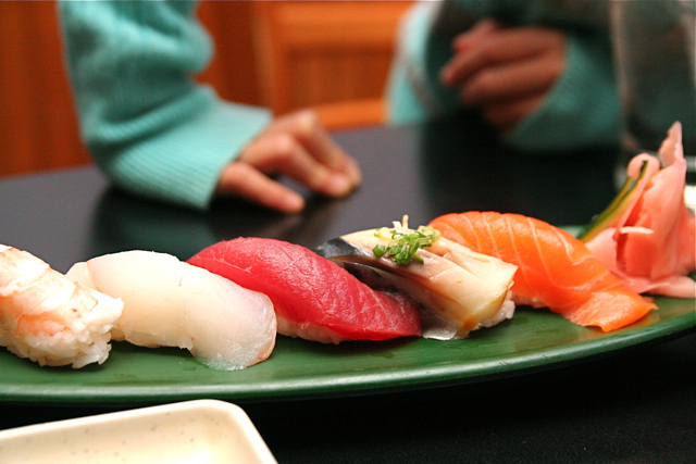various sushi are laying on a green plate