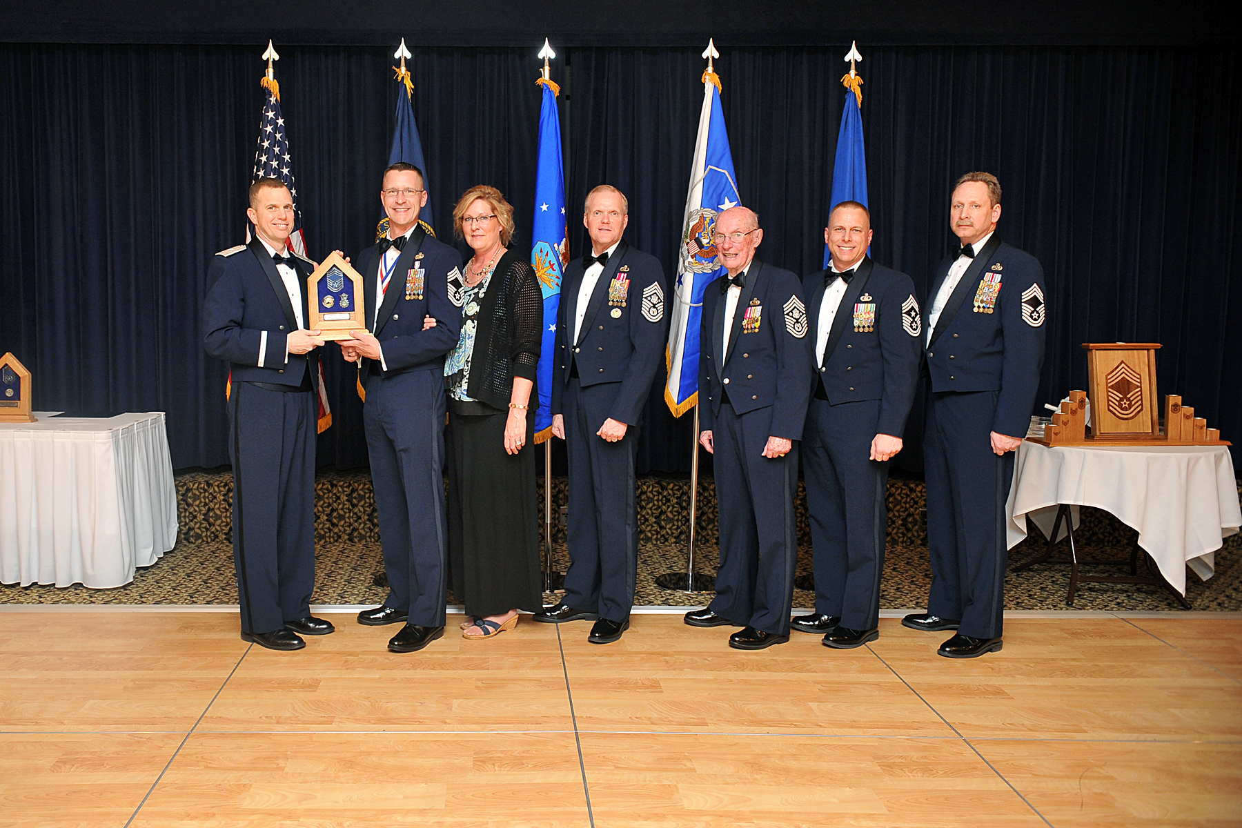 seven men in blue suits posing for a group po