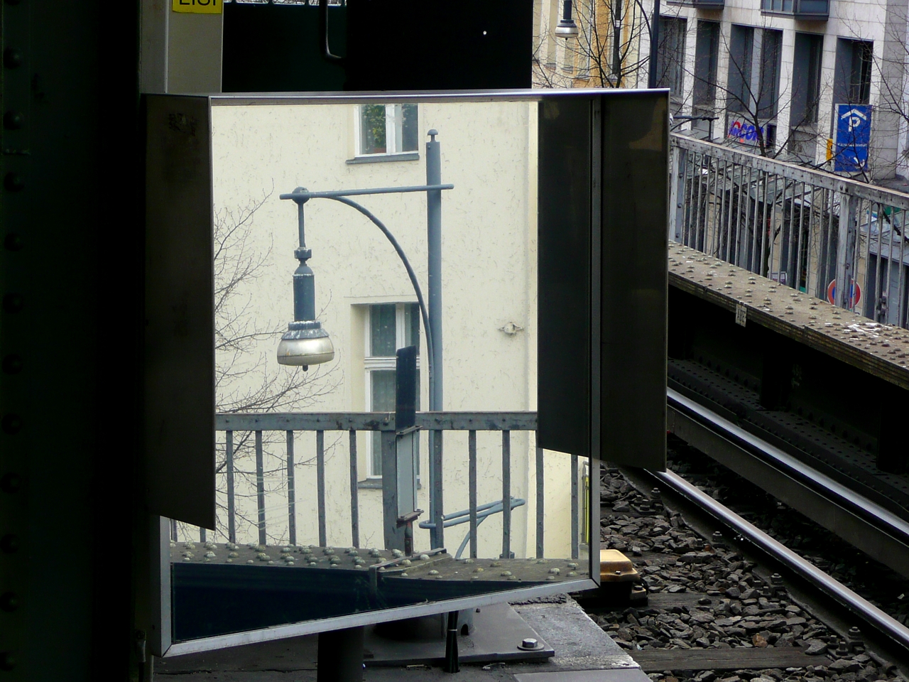 a reflection of the street light and the building in the mirror