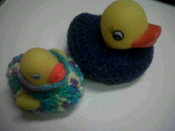 two rubber toys in a crocheted bag and one with a rubber duck