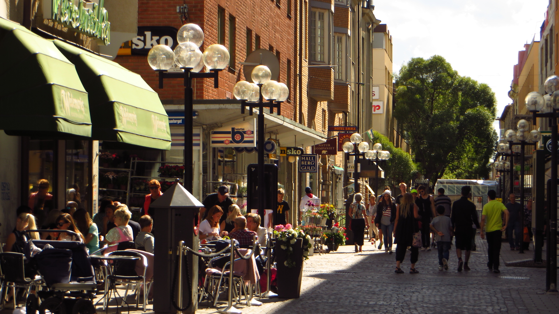 a street is crowded with people and people sitting at tables