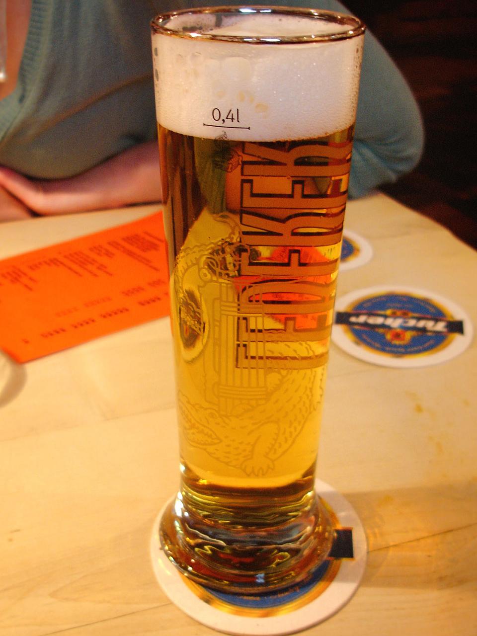 a tall glass with beer on a table