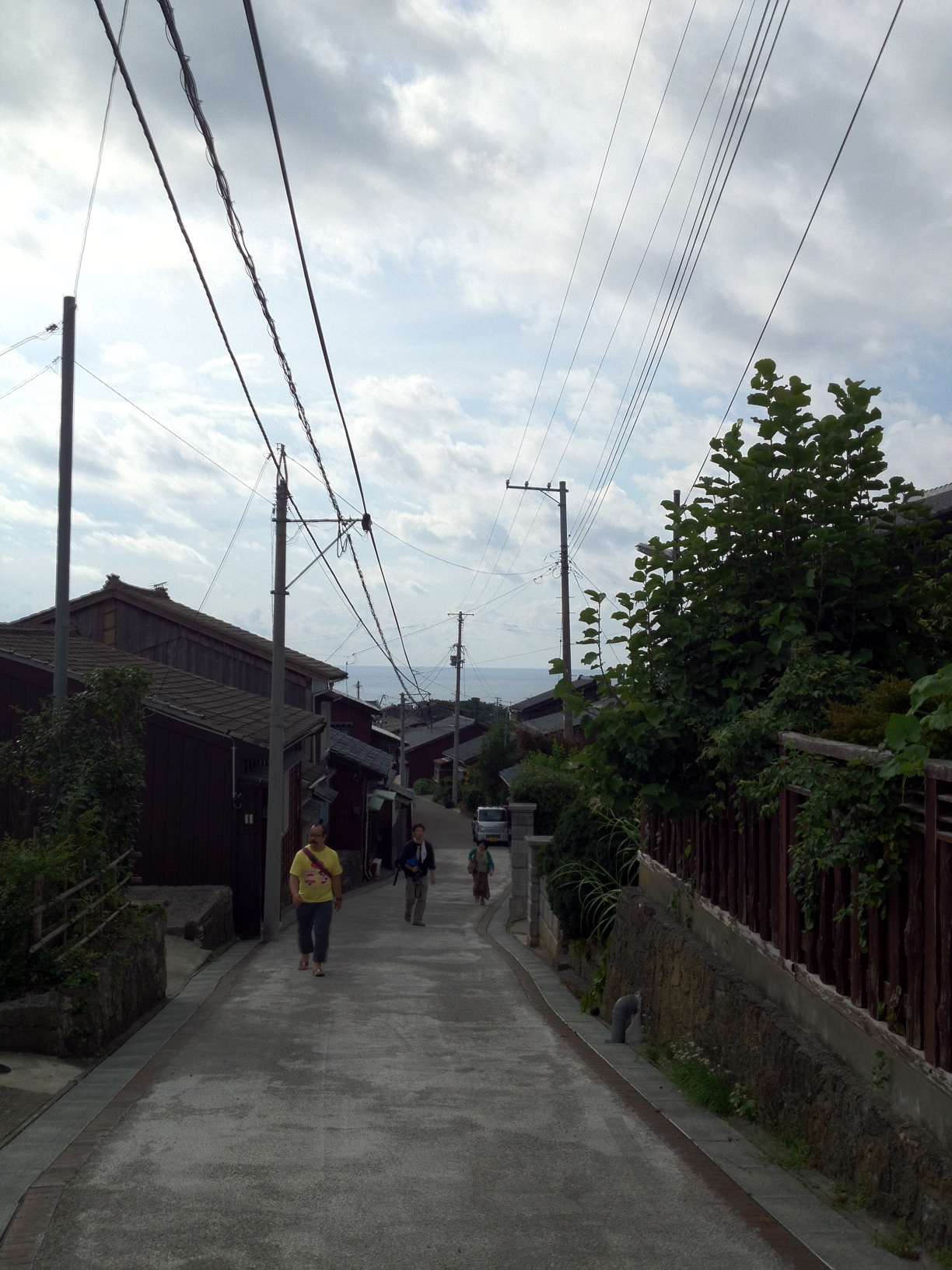 some people walking down a very long narrow street