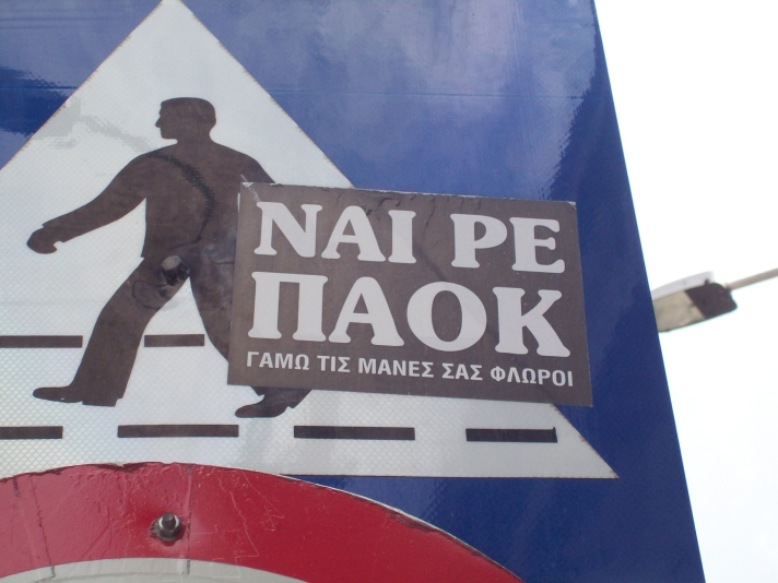 there is a sign that says nape taiok and a man walking across a road