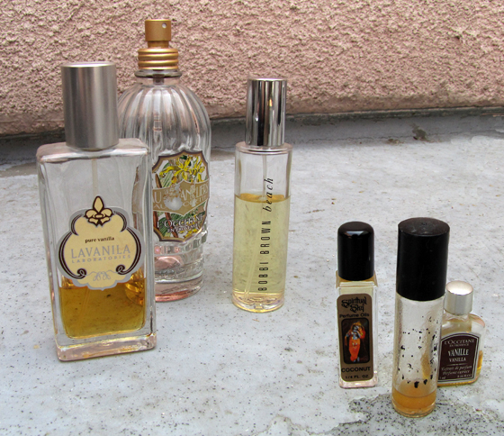 perfume bottles and various colognes are placed next to a wall