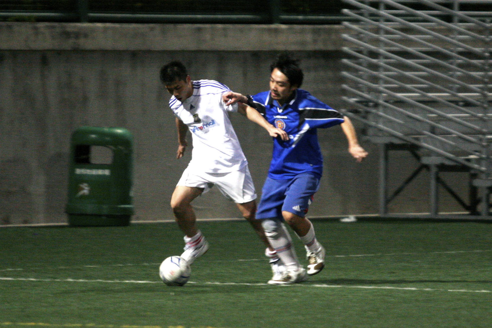 two male soccer players are attempting to control the ball