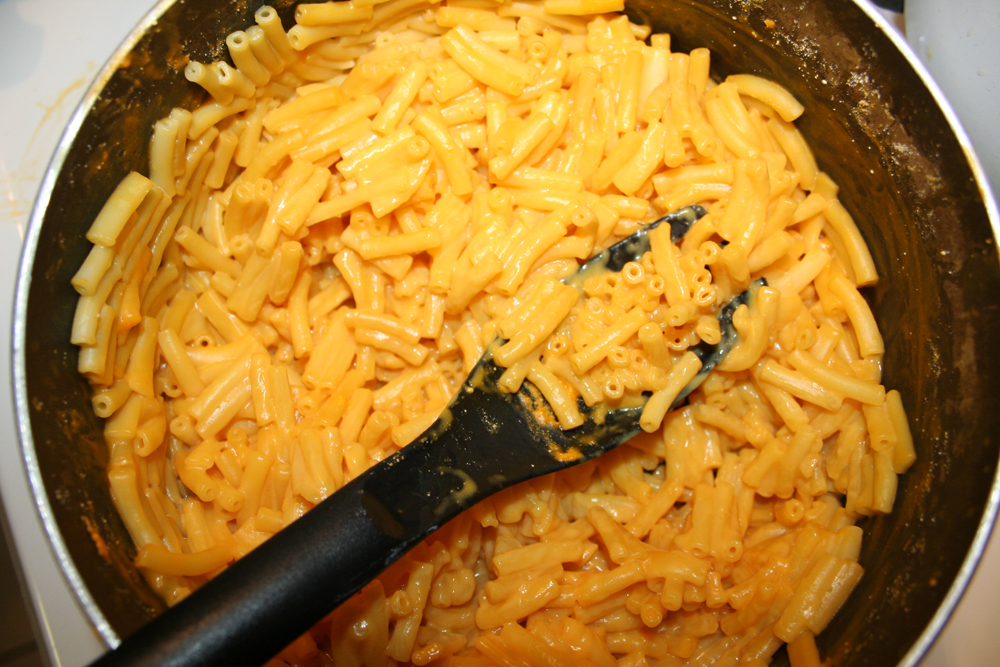 macaroni and cheese in a bowl next to a black spatula
