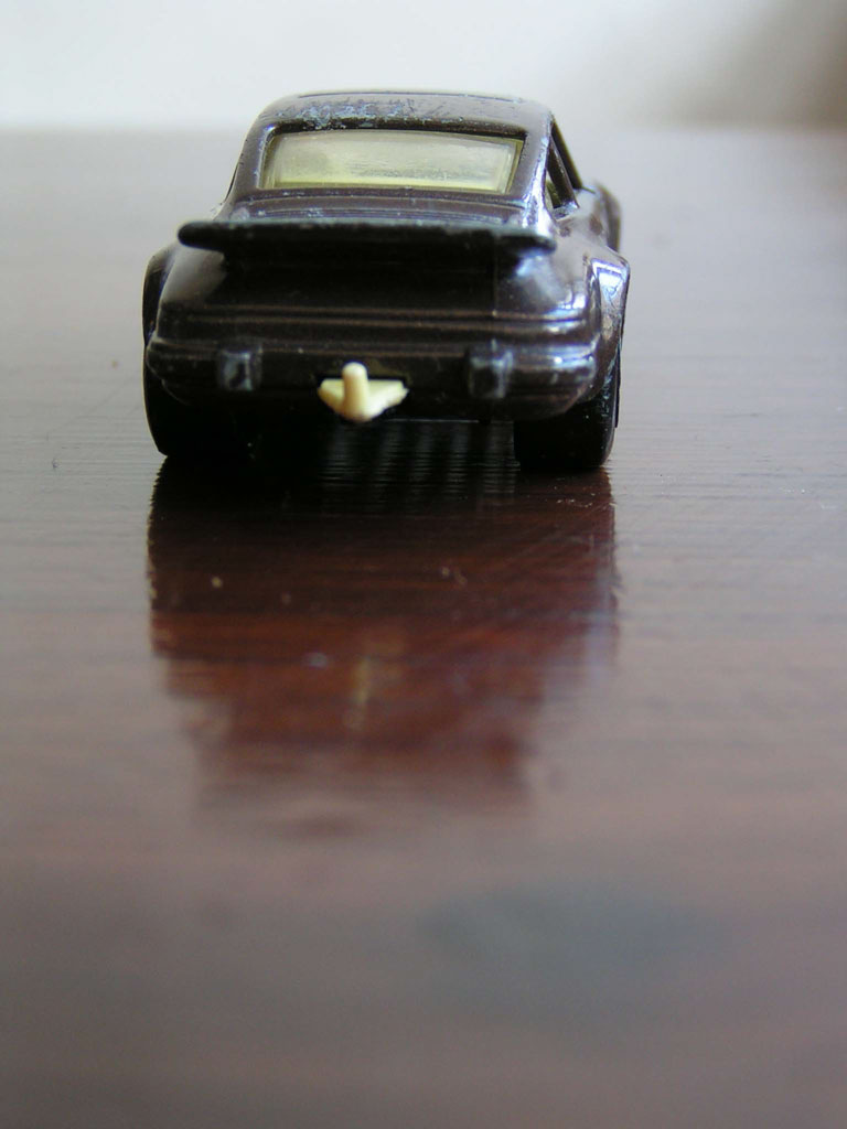 a toy car sits on a table and has some candy in the back