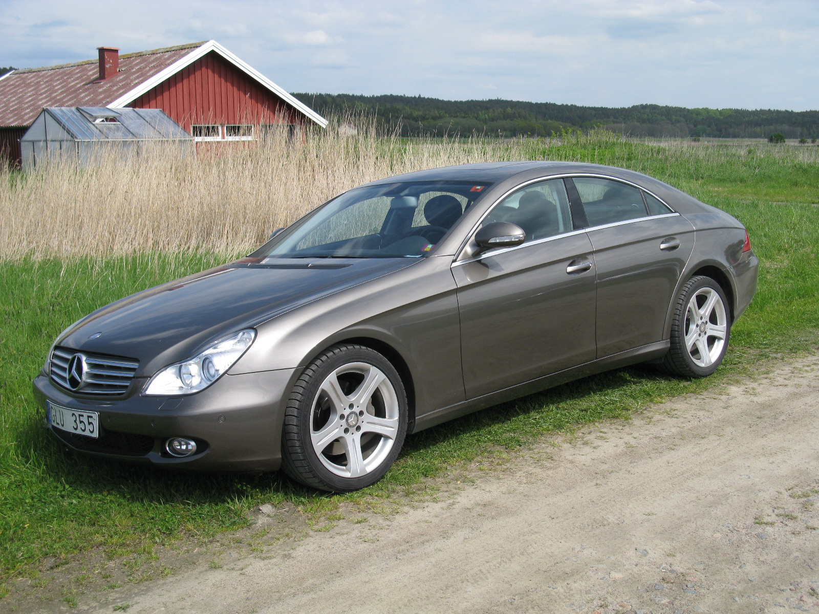 a silver mercedes benz cls parked on a rural road