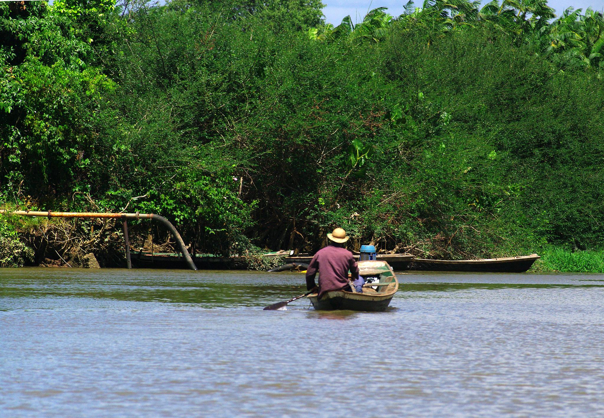 a man wearing a cowboy hat is in the water in a small boat