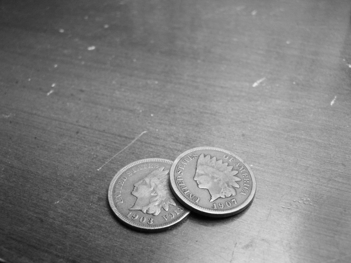 two coins are laying on a metal surface