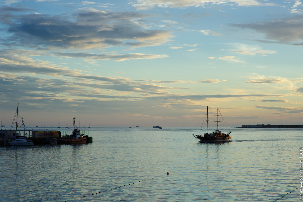 a number of boats in the water at sunset