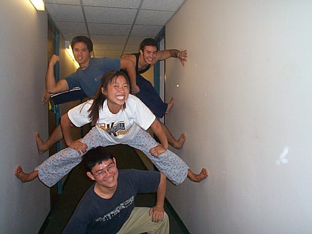 four people in an hallway and two are jumping
