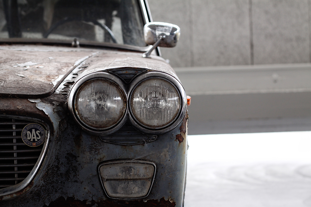 an old, rusty old sports car, with its hood slightly opened