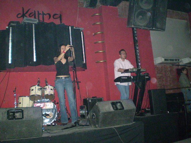 a woman is on stage playing music at a party