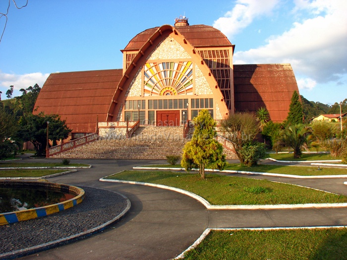 a large building with a huge, curved front and a circle garden in front