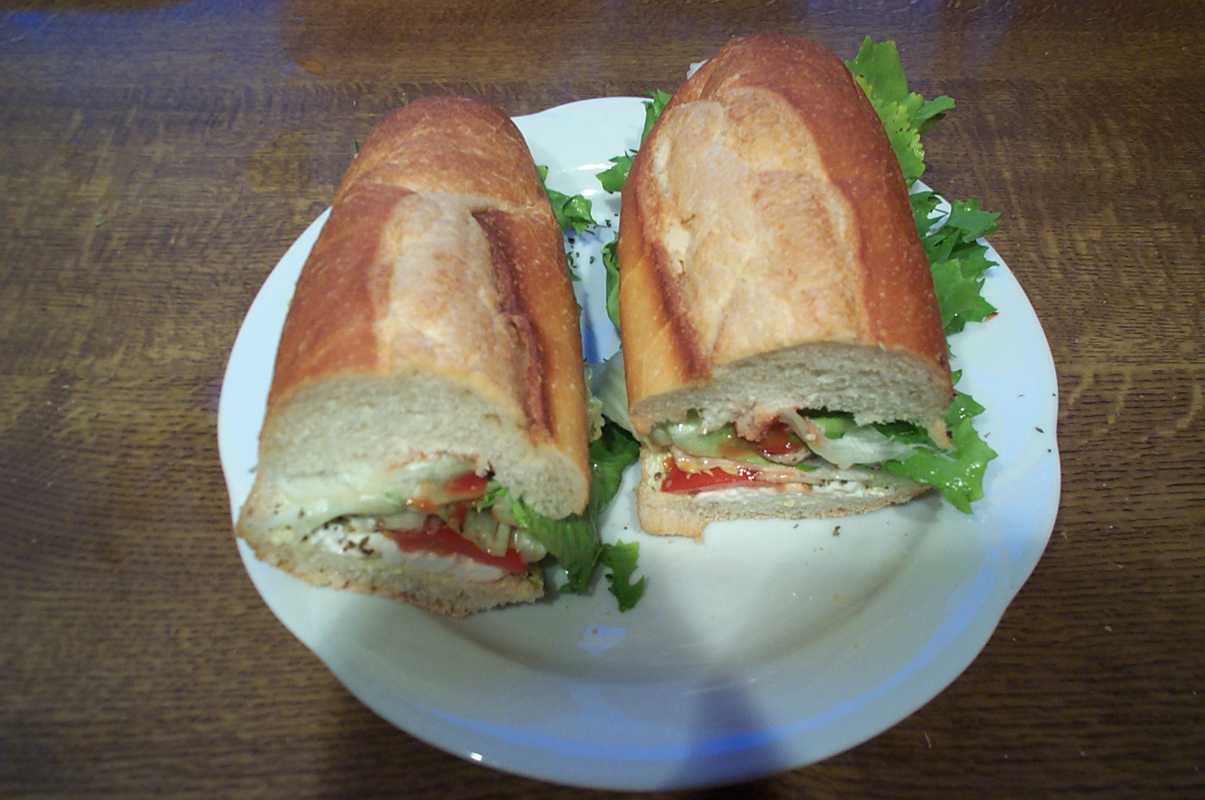 a large sandwich cut in half on a white plate